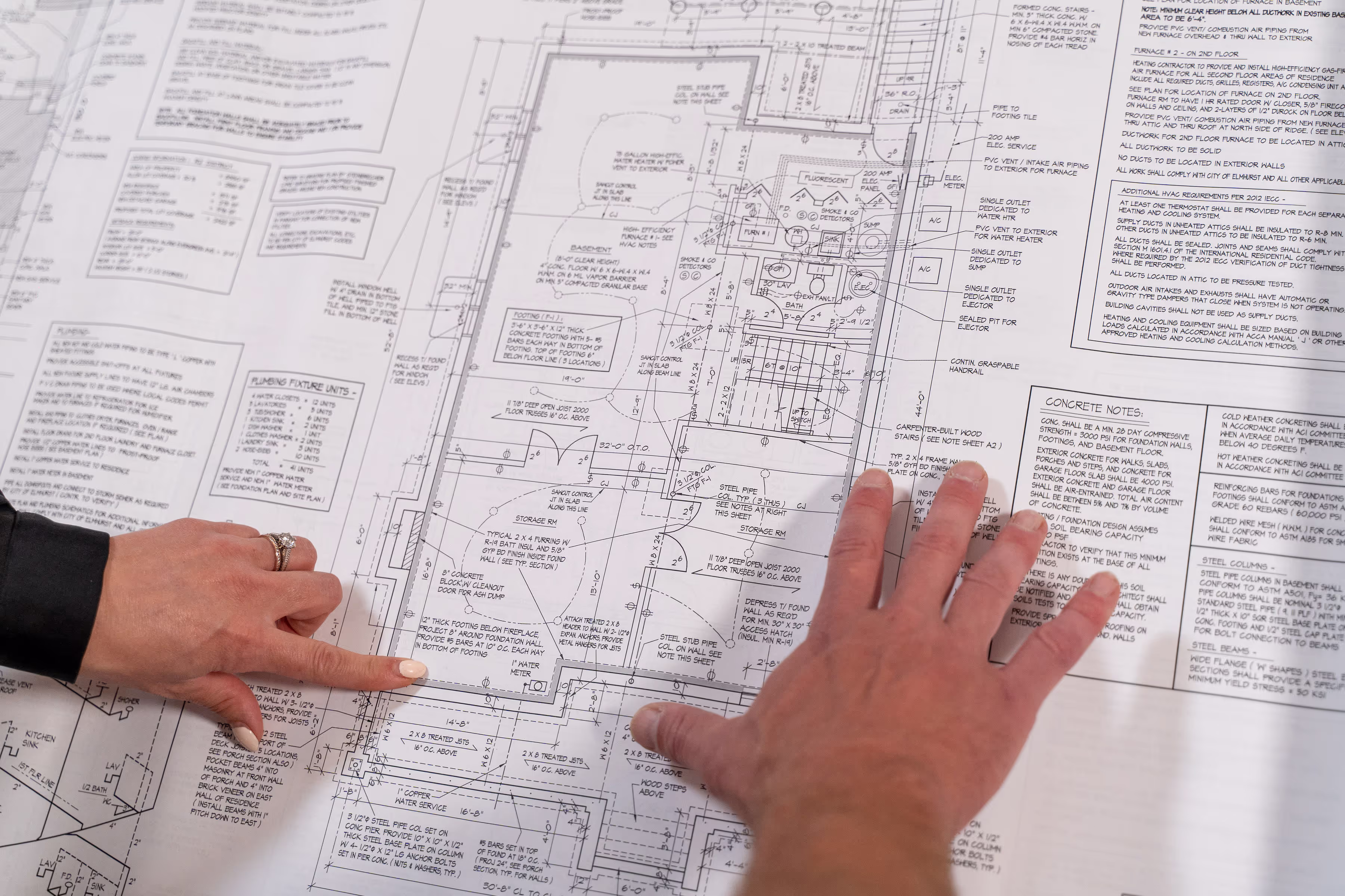 Photo of partners reviewing gym blueprints